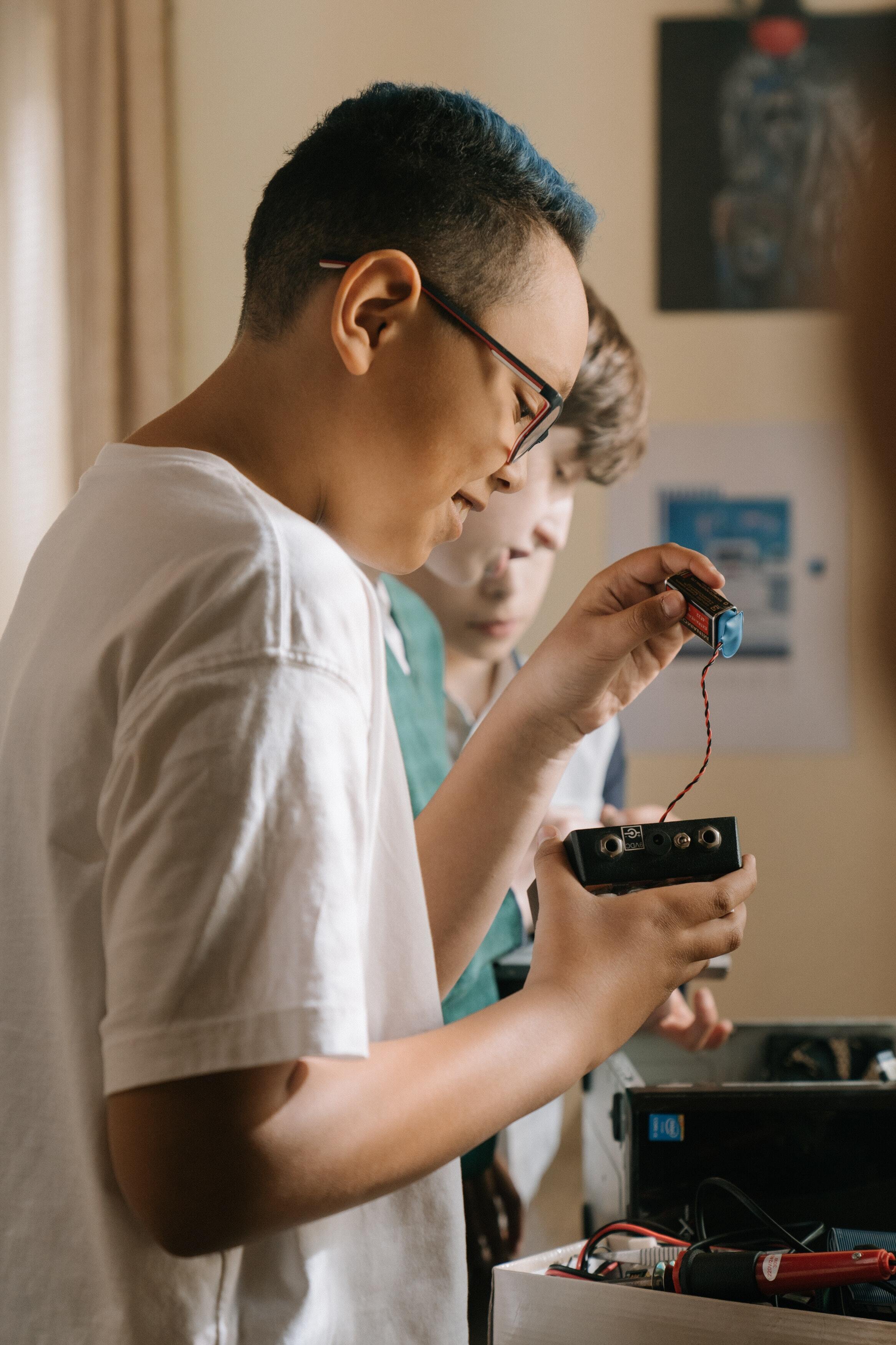 a young boy connecting a battery to a device