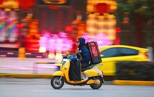 A man rides an electric bike to deliver take-out