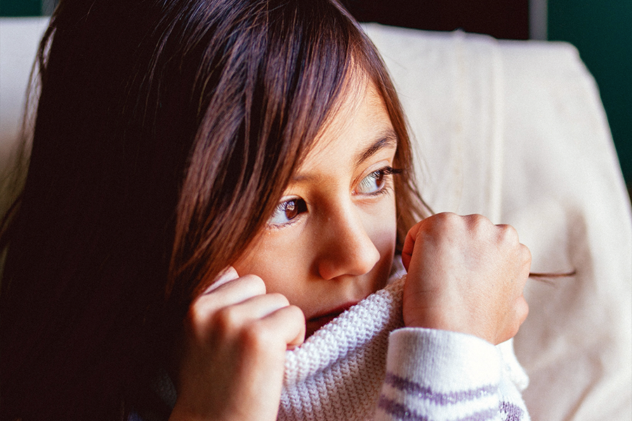 A young girl trying to hide her face