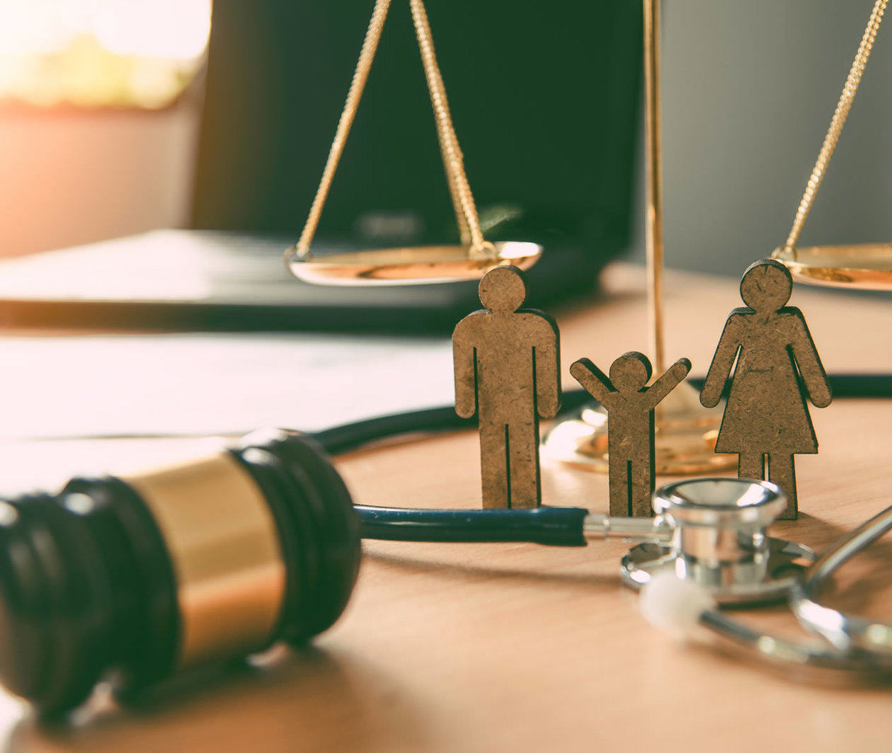 Close up of gavel, books, and human figurines on a desk.
