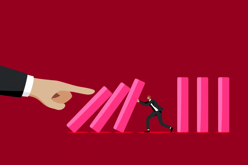 An illustration. A series of dominoes falling being pushed by a large finger - a board director tires to hold the domino up