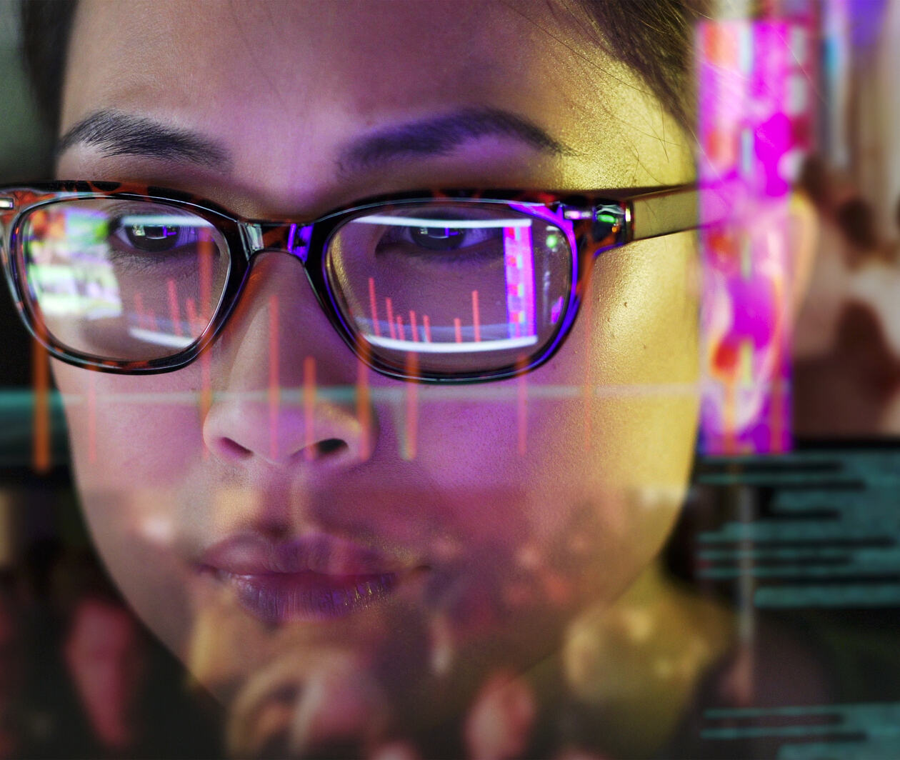 A woman looking at a projector screen which is showing graphs of data