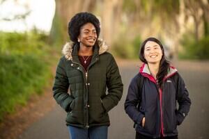 Two students walking through the woods