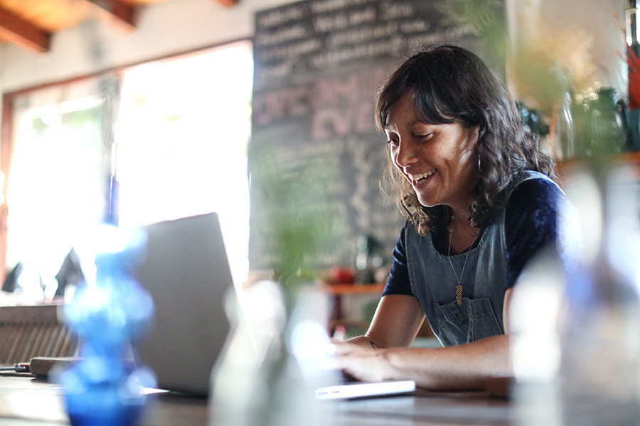 Woman using her laptop in her kitchen at home.