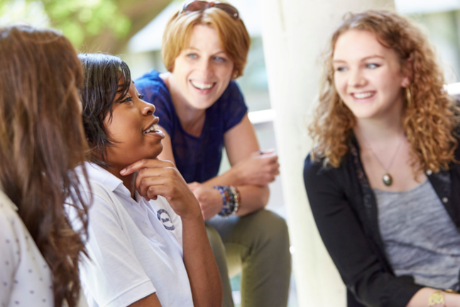 Four carers speaking with peers outside while enjoying the discussion