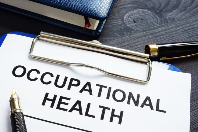 Illustration sheet with Occupaional Health written on it on a clip board and a pen lying next to it