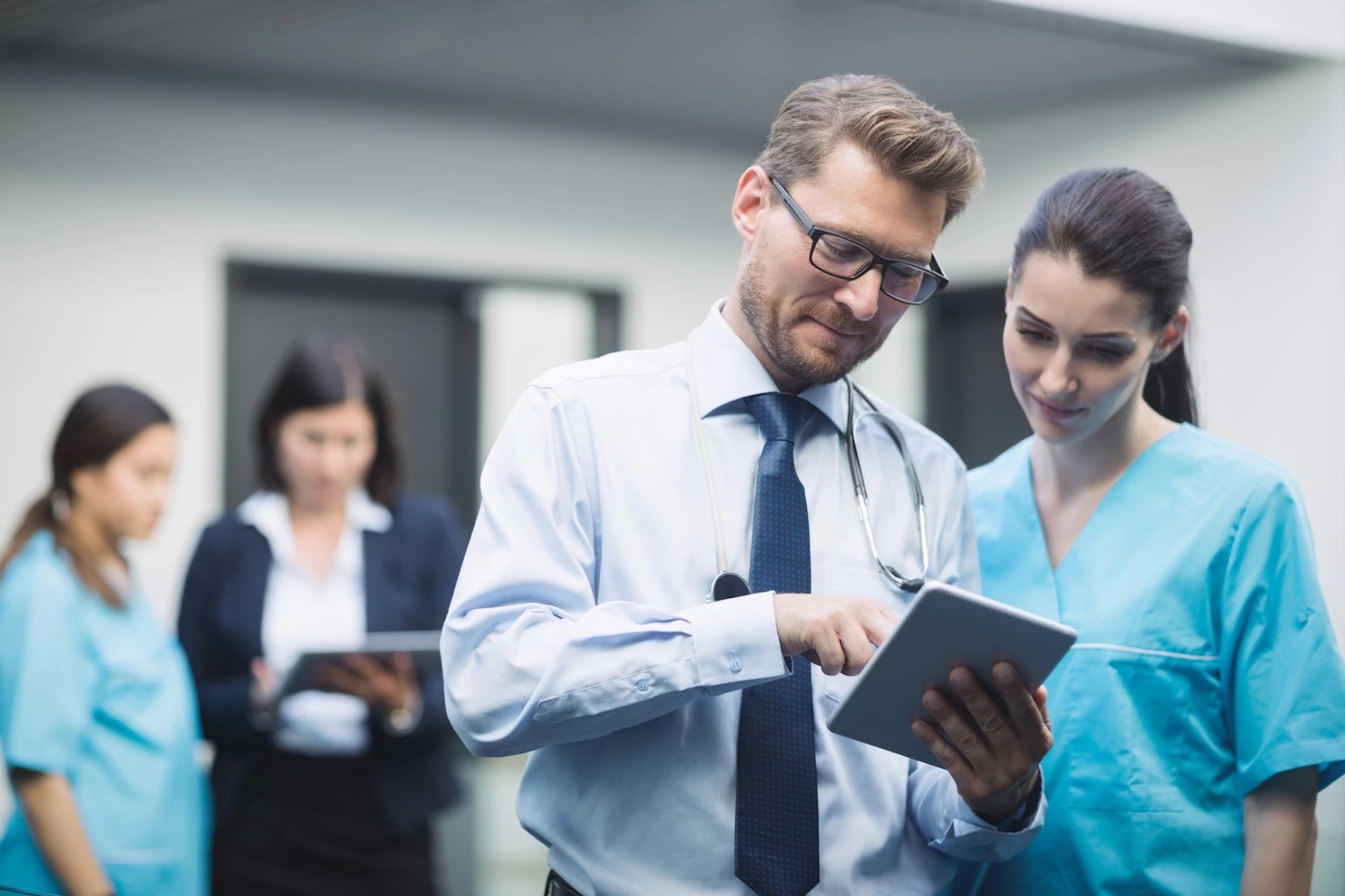 doctor and nurse discussing over digital tablet