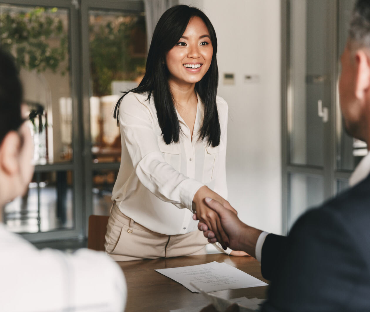 Woman shaking hands with interviewers 