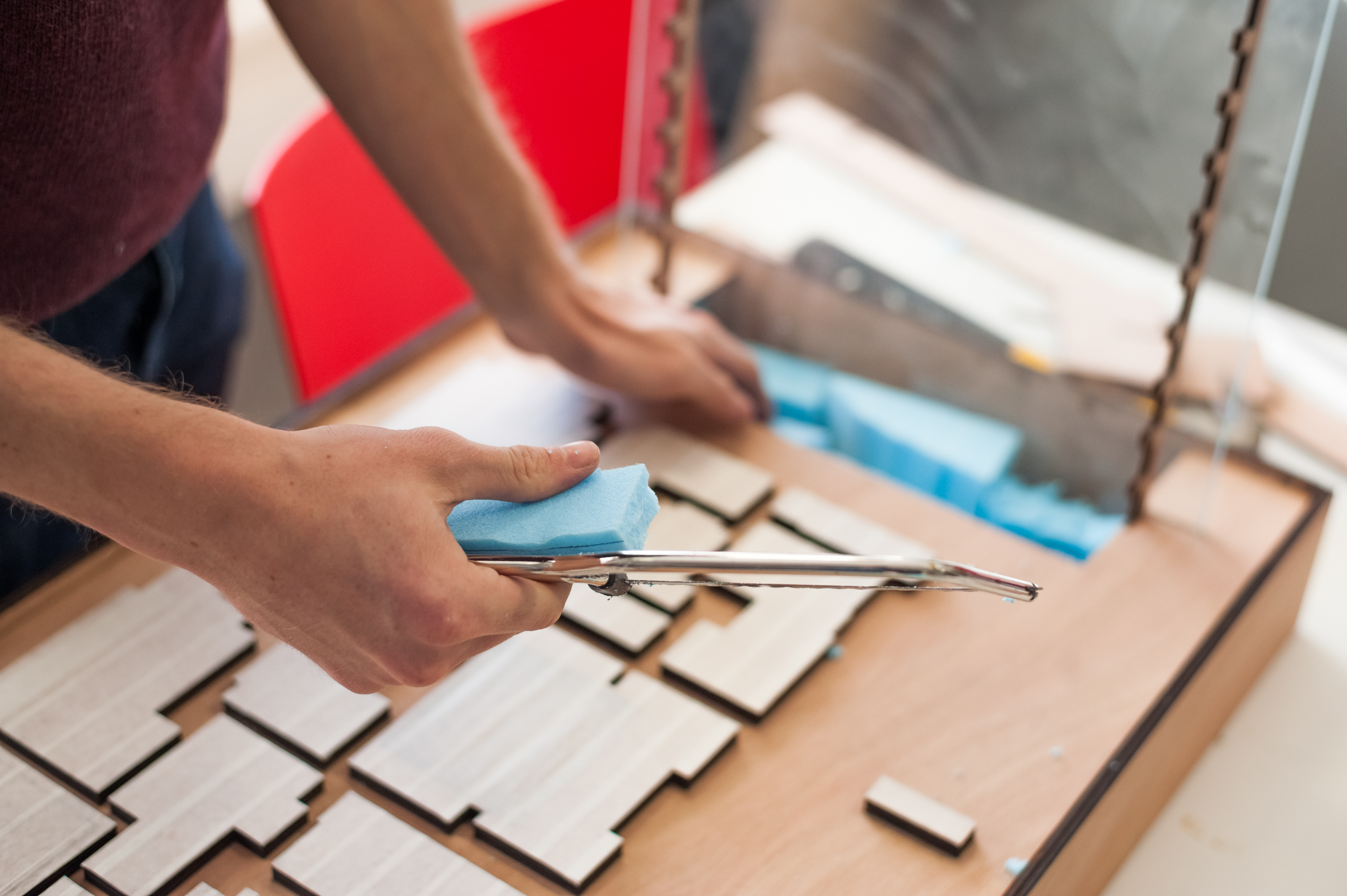 Close up of student hands working on an architectural 3D model
