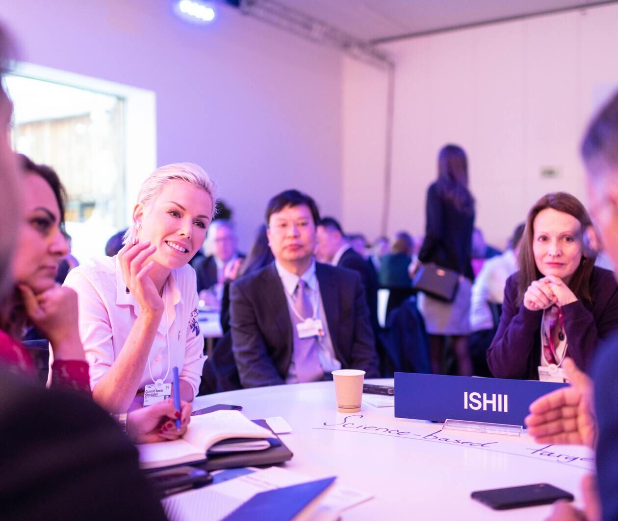 a group of people around a table at a conference