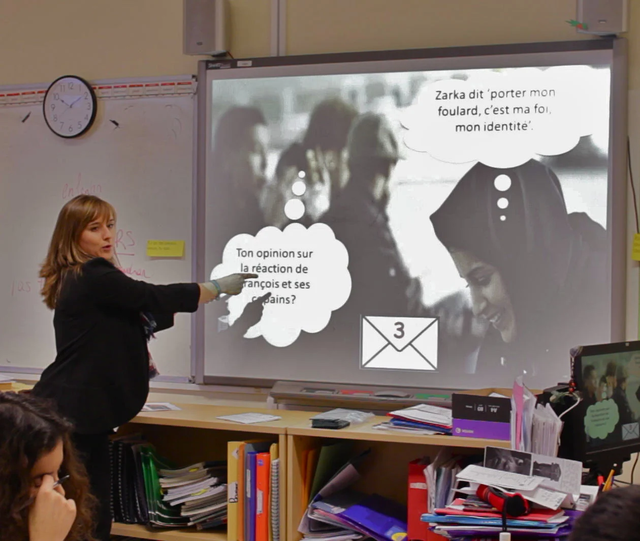 Lead educator Muriel teaching language in a classroom at the whiteboard