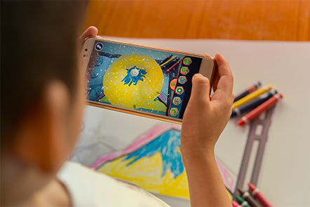 Niño usando la aplicación de dibujo AR en un dispositivo móvil