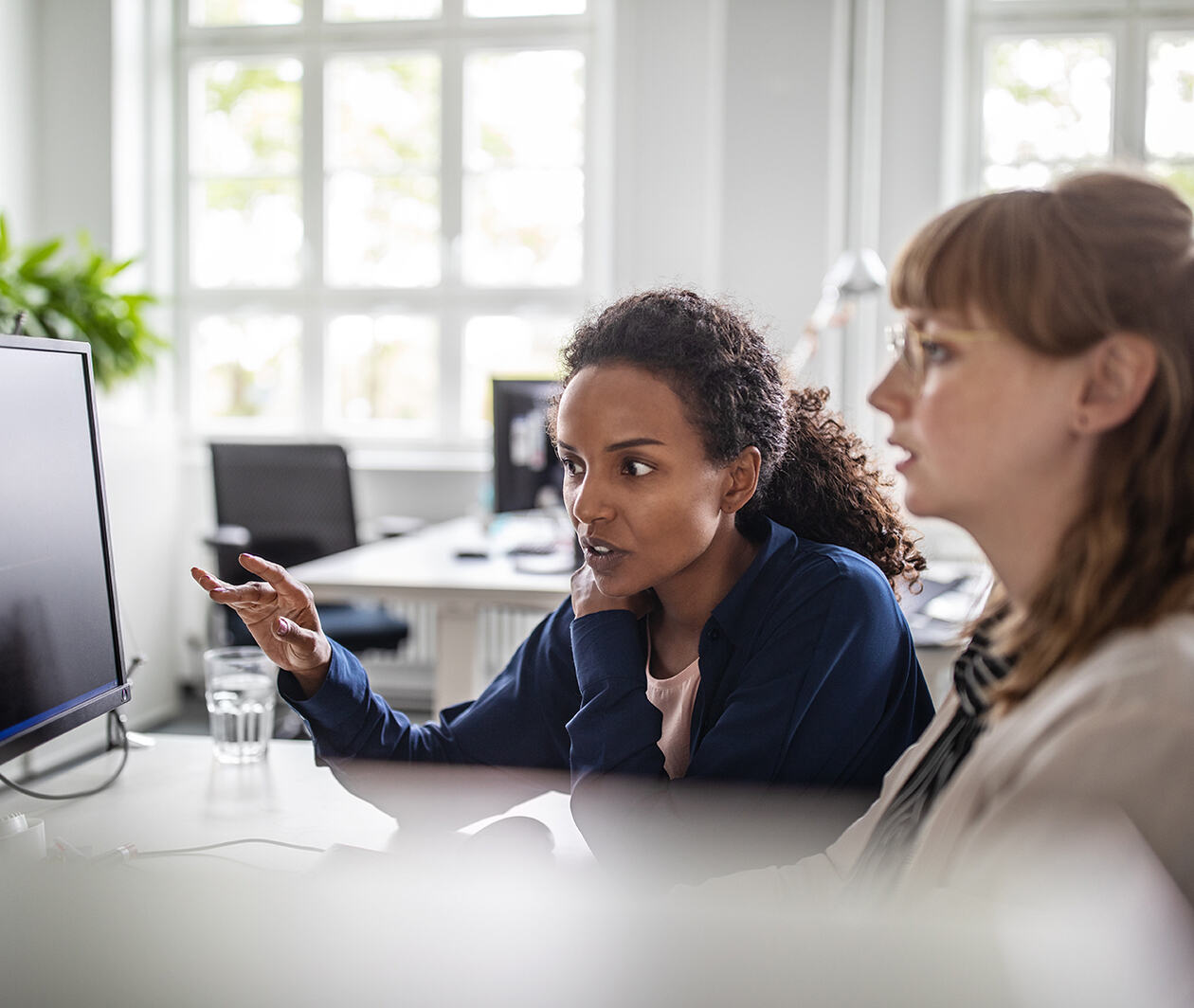 Business women discussing data on a computer screen in the office