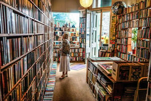 A woman in a bookshop in Edinburgh, staring at the shelves.