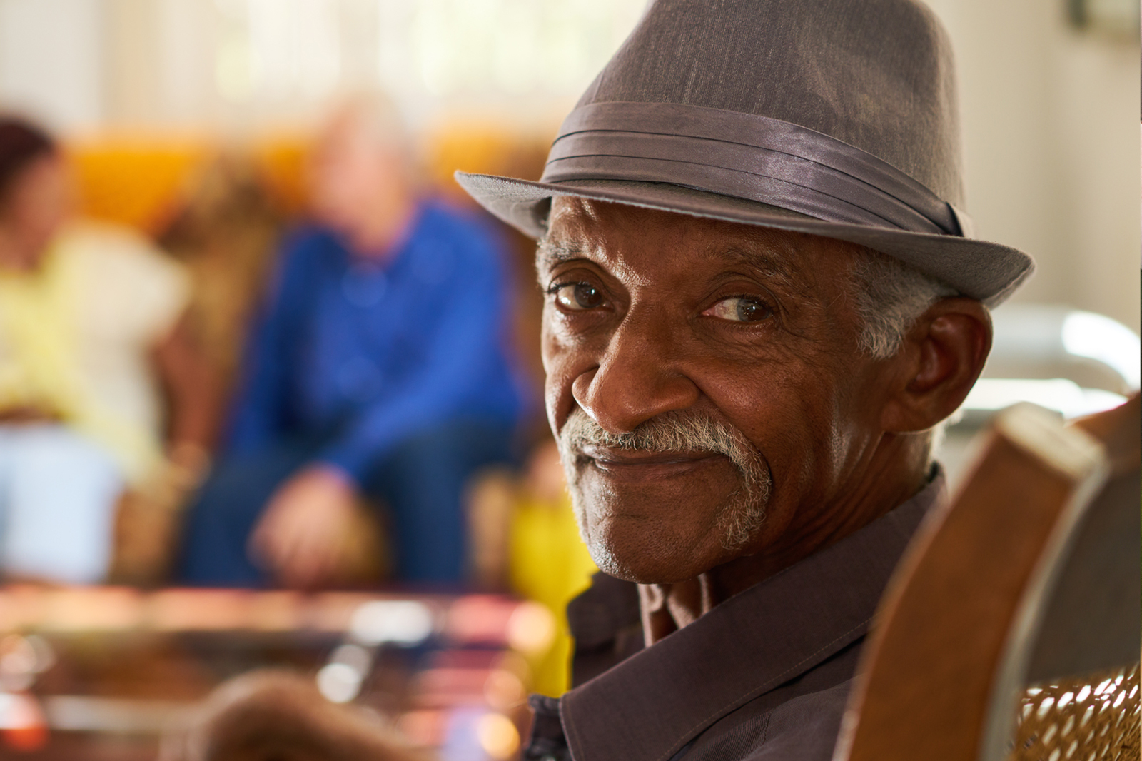 Elderly man wearing a hat looking into the camera