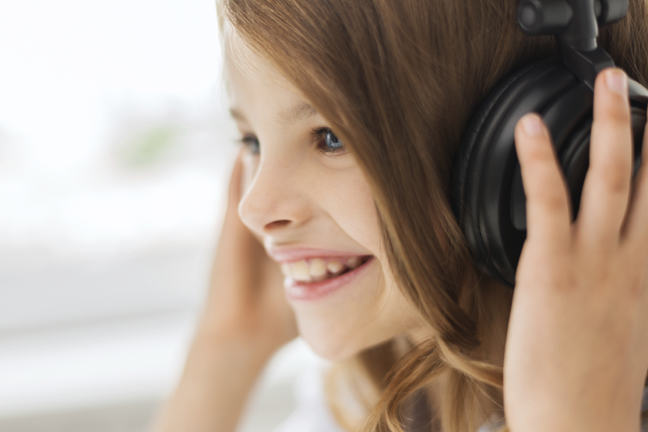 Close up image of girl with headphones on listening to sounds
