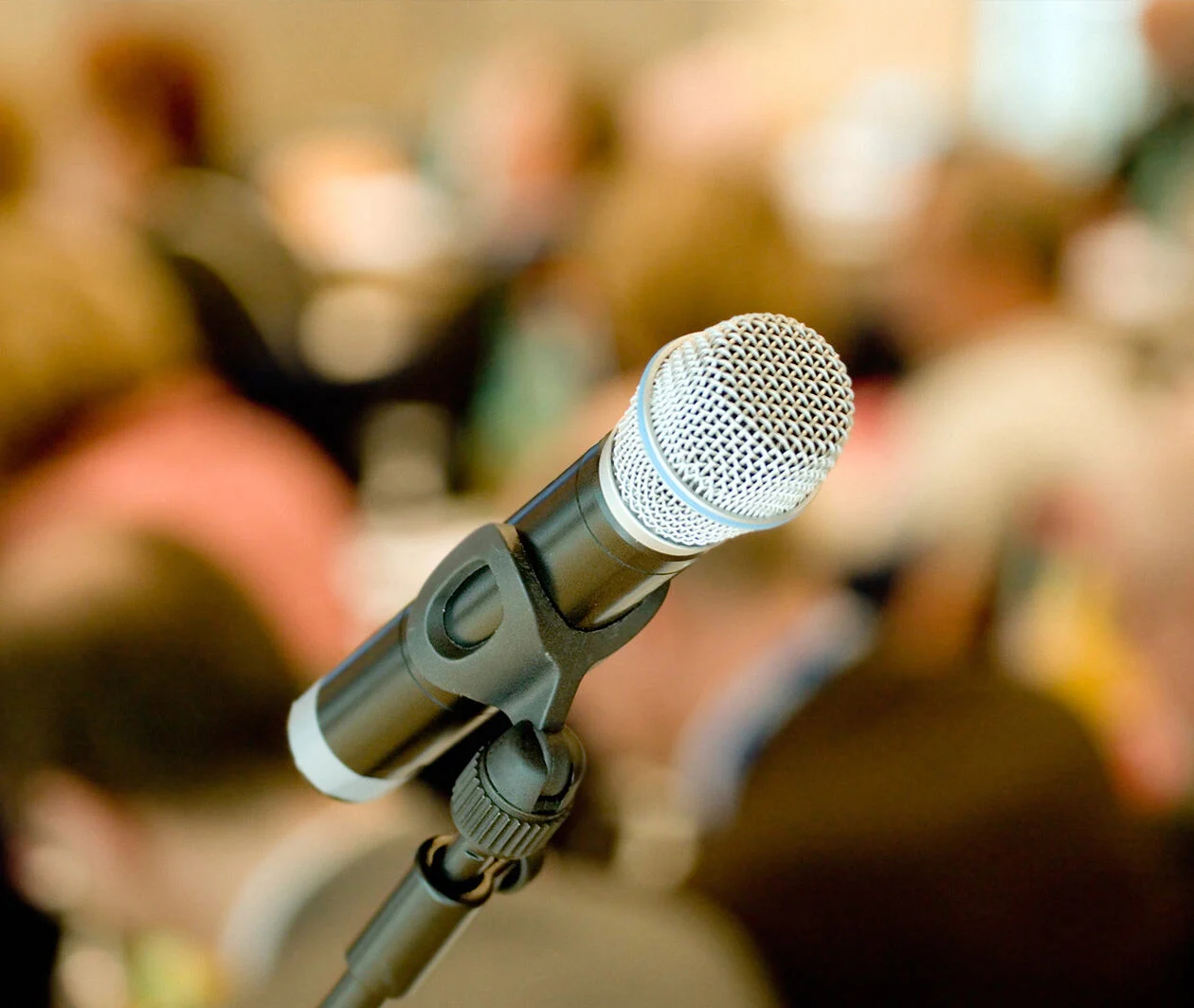 An image of a microphone in front of an audience