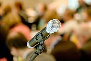 An image of a microphone in front of an audience