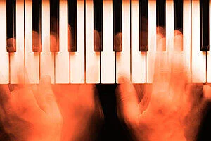 A pair of hands on a keyboard, playing jazz piano