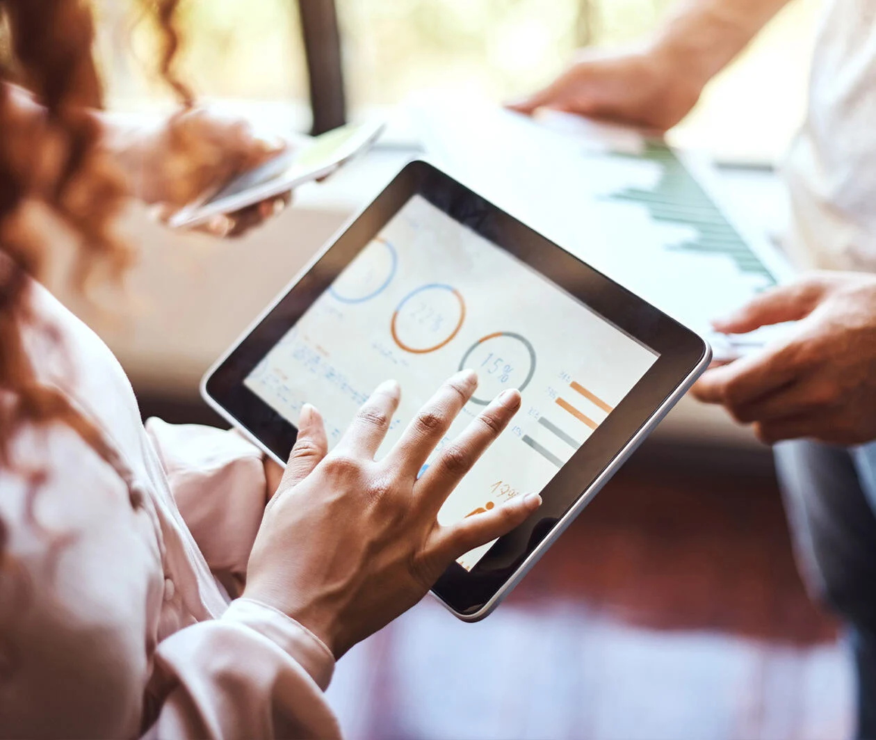 Person with tablet showing data dashboard