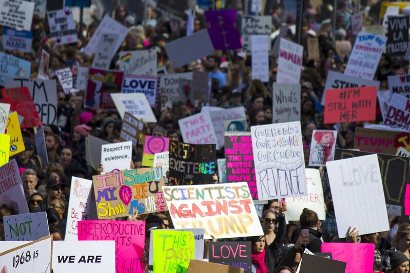 A large number of activists from women's march taken place in Los Angeles. The activists are holding various signs that make statements on highly polarized debates such as reproductive rights.