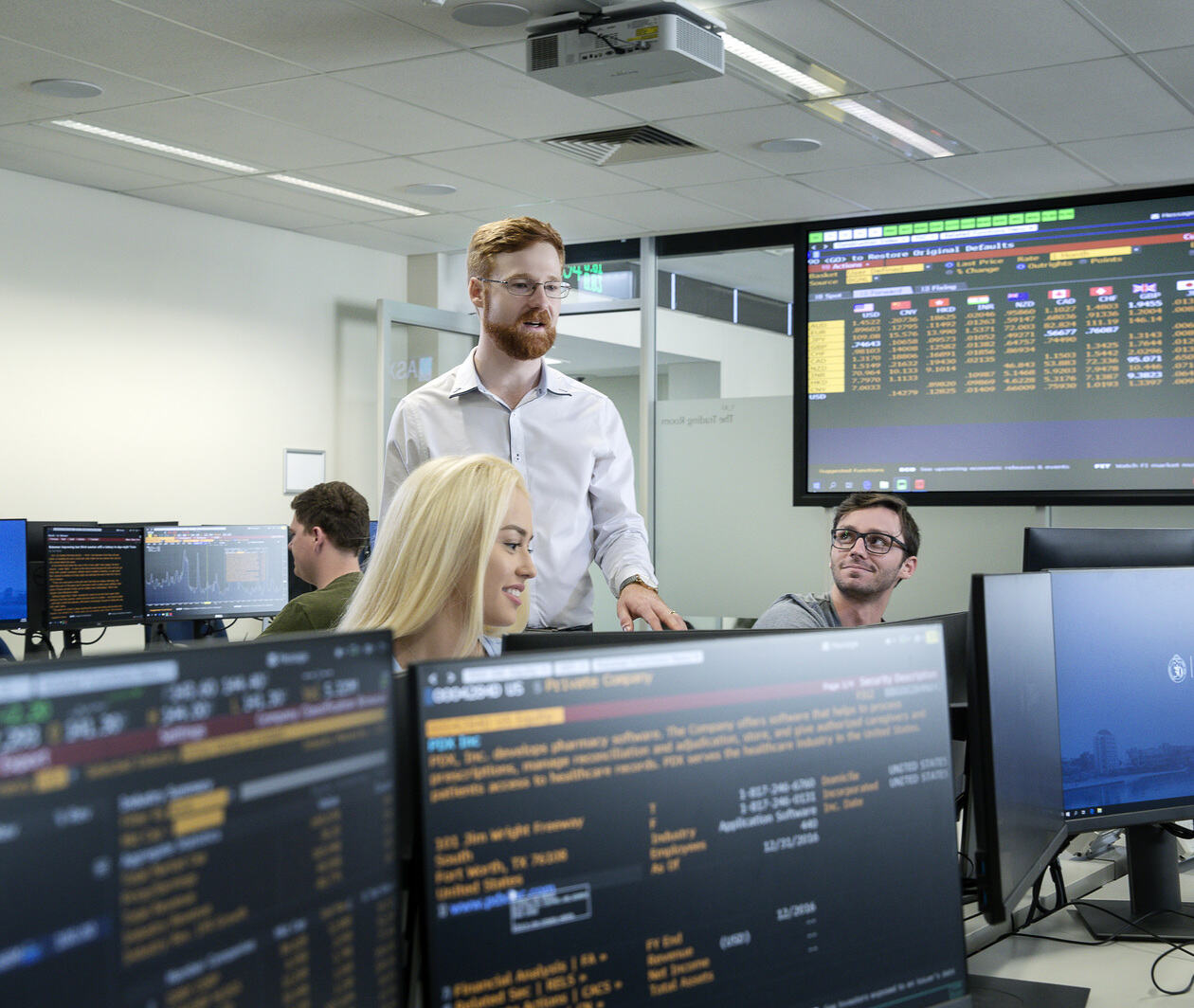 a professor looking over students at computers