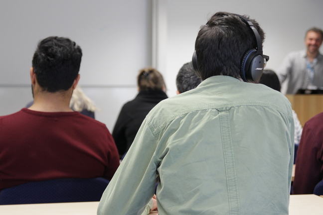 A diverse group of learners sitting at desks in a lecture