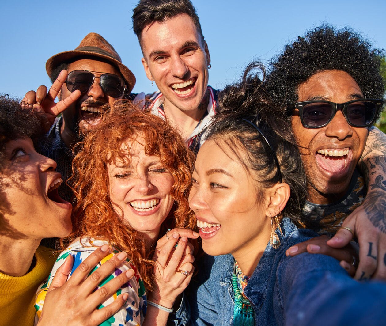 Friends in different ethnic group meeting up on a summers evening, having fun together.