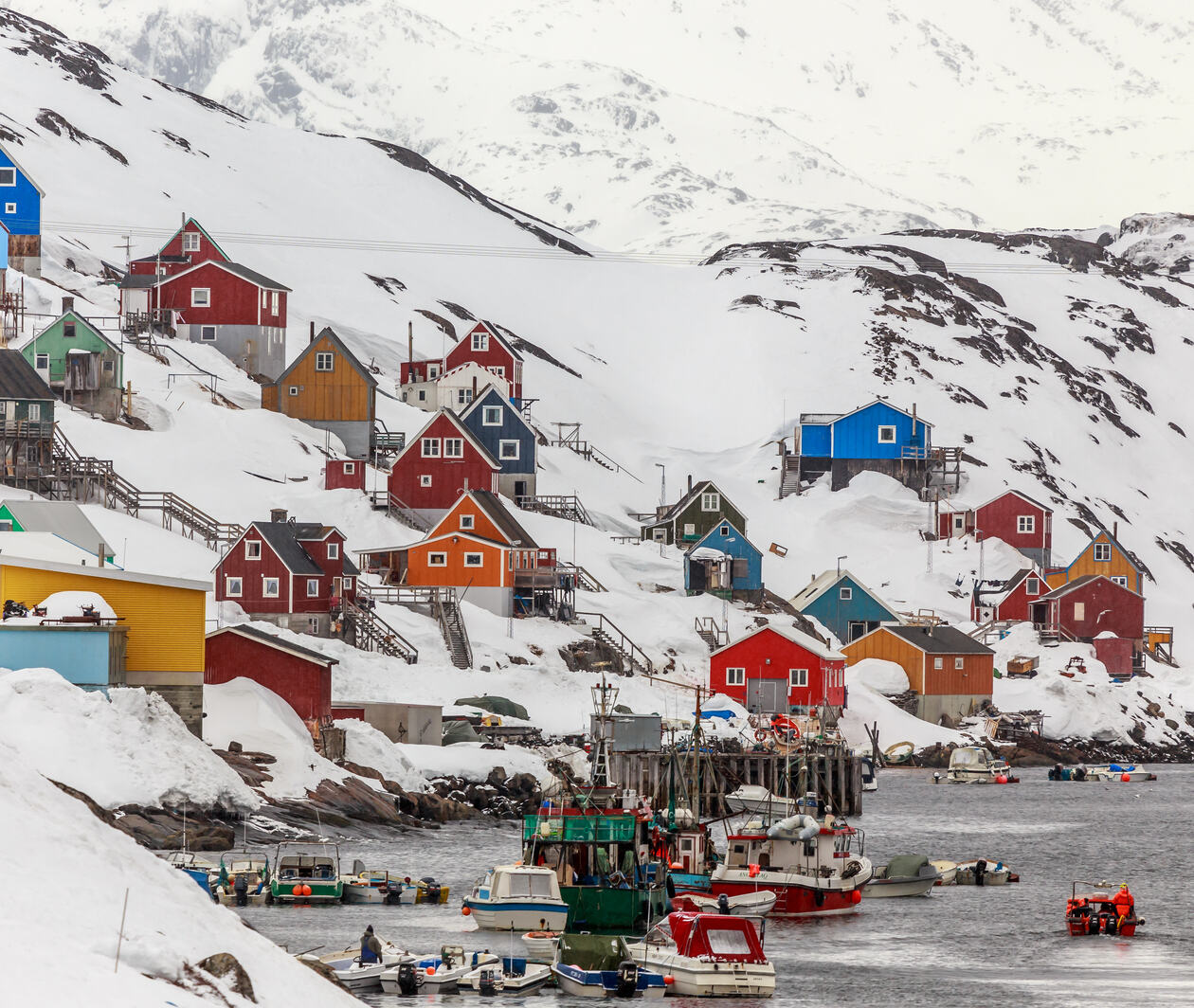 Kangamiut village, Greenland May 2015 - a collection of colourful houses on a snowy hillside, with a small harbour below