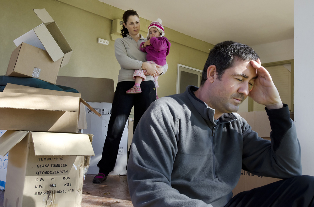 Young parents and their daughter with cardboard boxes.