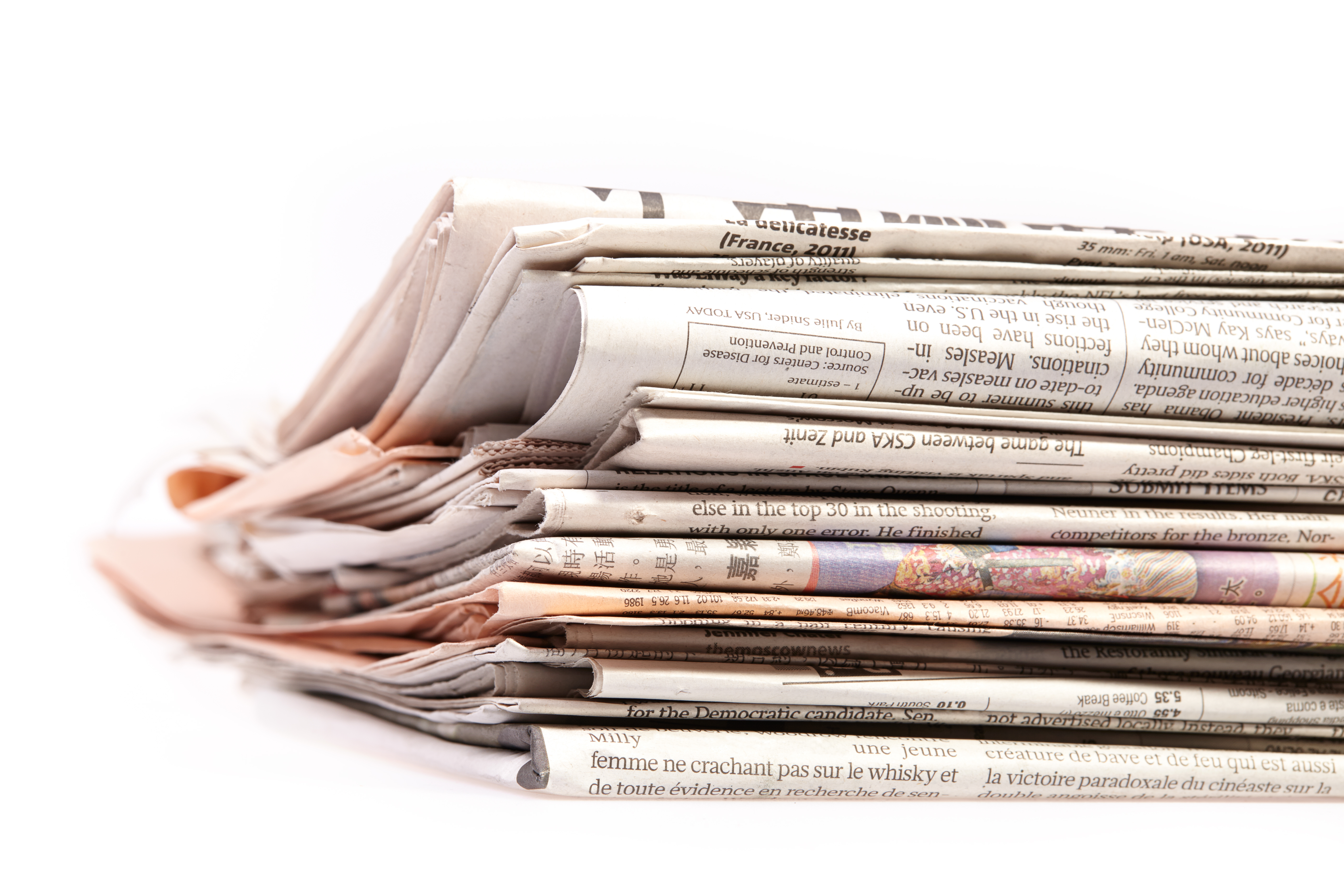 Pile of folded international newspapers and reports