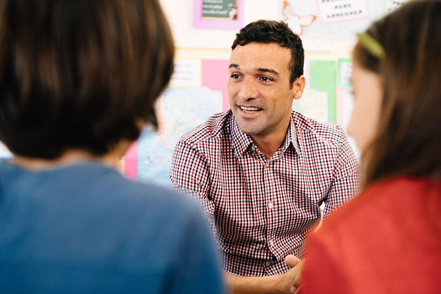 Male counsellor talking with group of young people