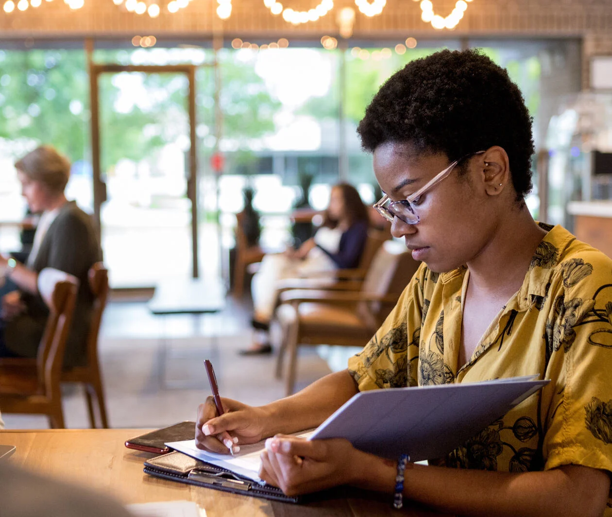 Female journalist writing up a news article for publication.