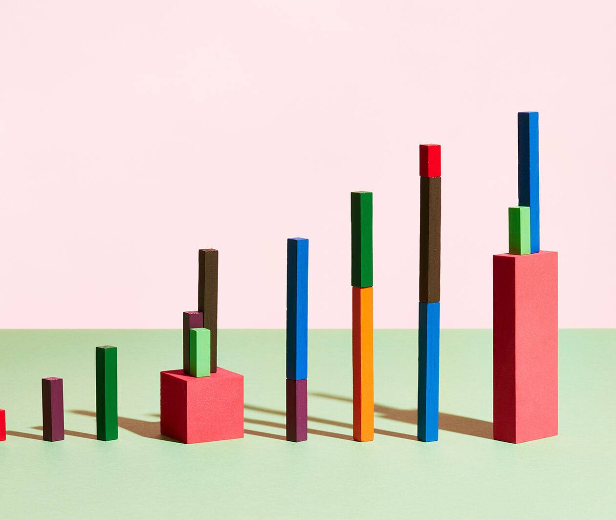 Colourful blocks are lined up in a bar chart formation in a pink and green room. 