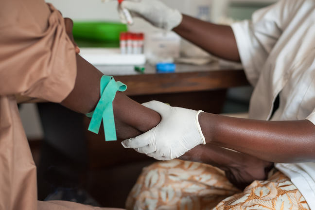 A healthworker taking a blood sample from a woman.