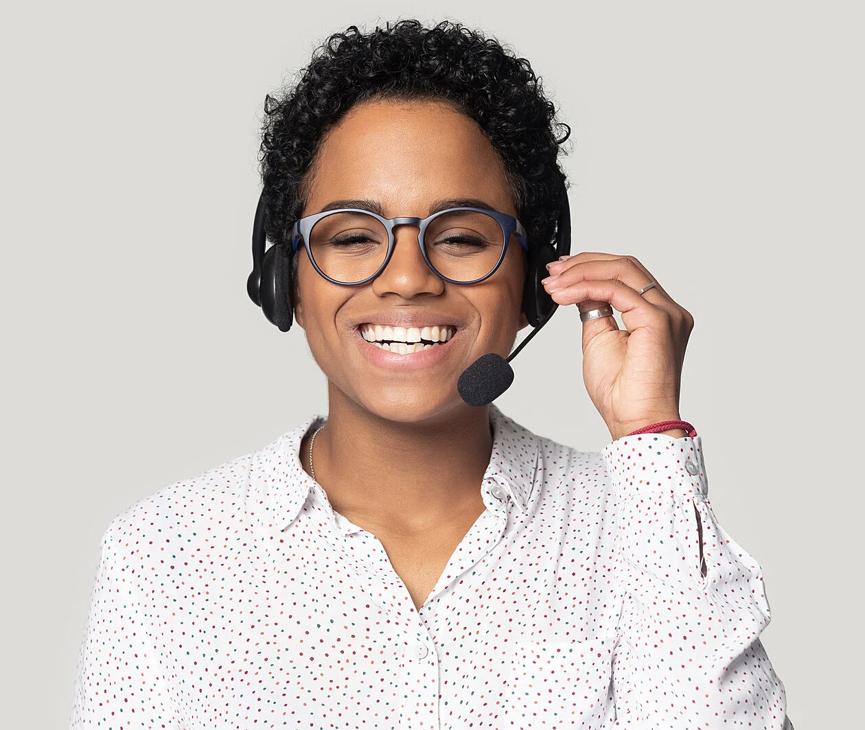 A woman of african ethnicity smiling and wearing a headset