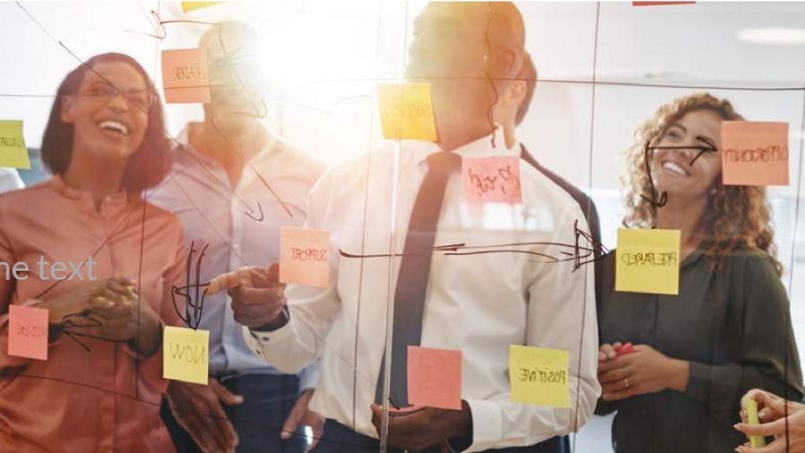 4 people on far side of transparent screen with post-it notes