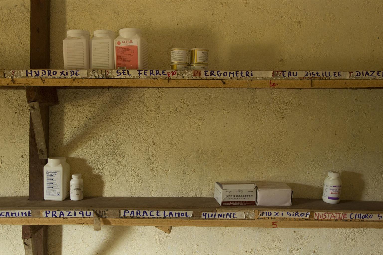 The shelves of village pharmacy are shown in this image. The shelves have a small supply of medication on them.