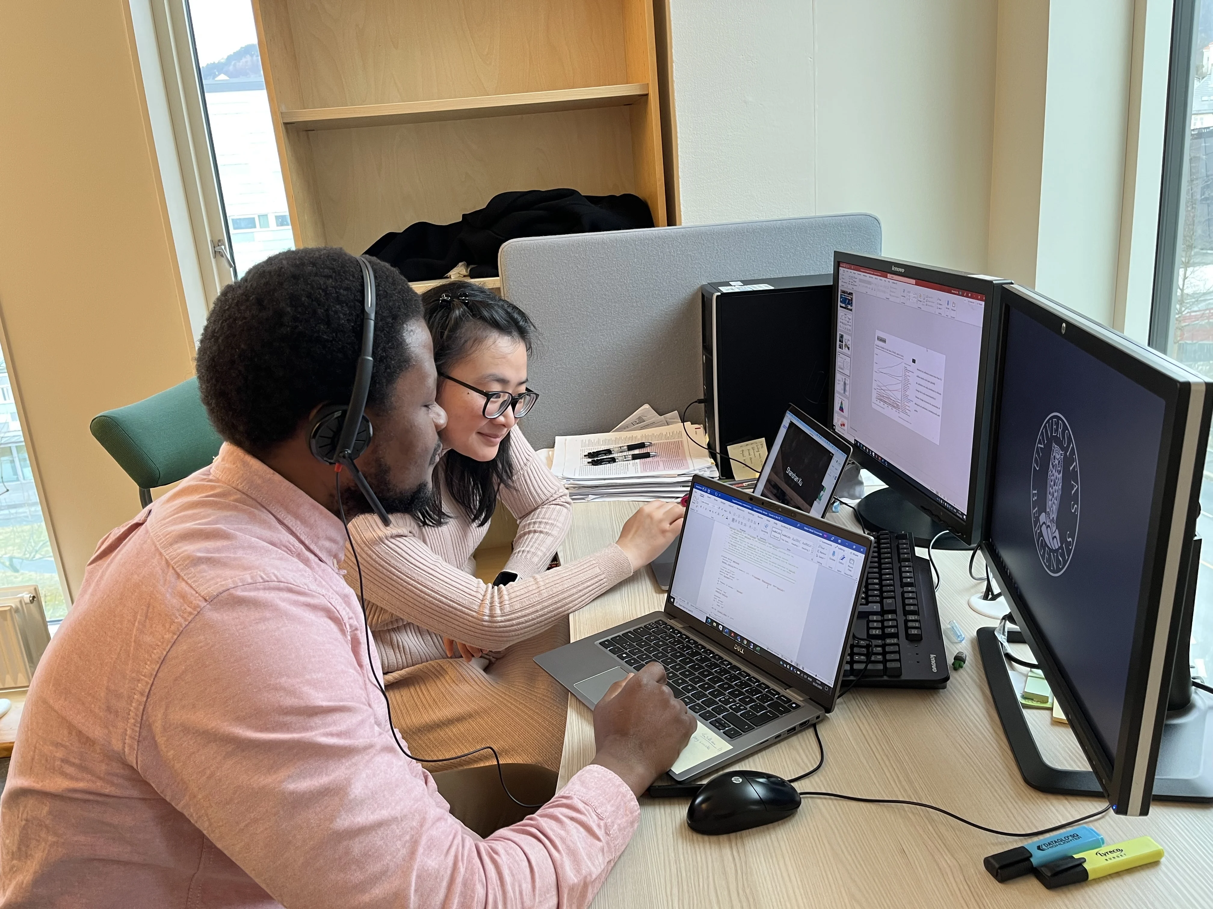 Two workers in front of computers in office environment