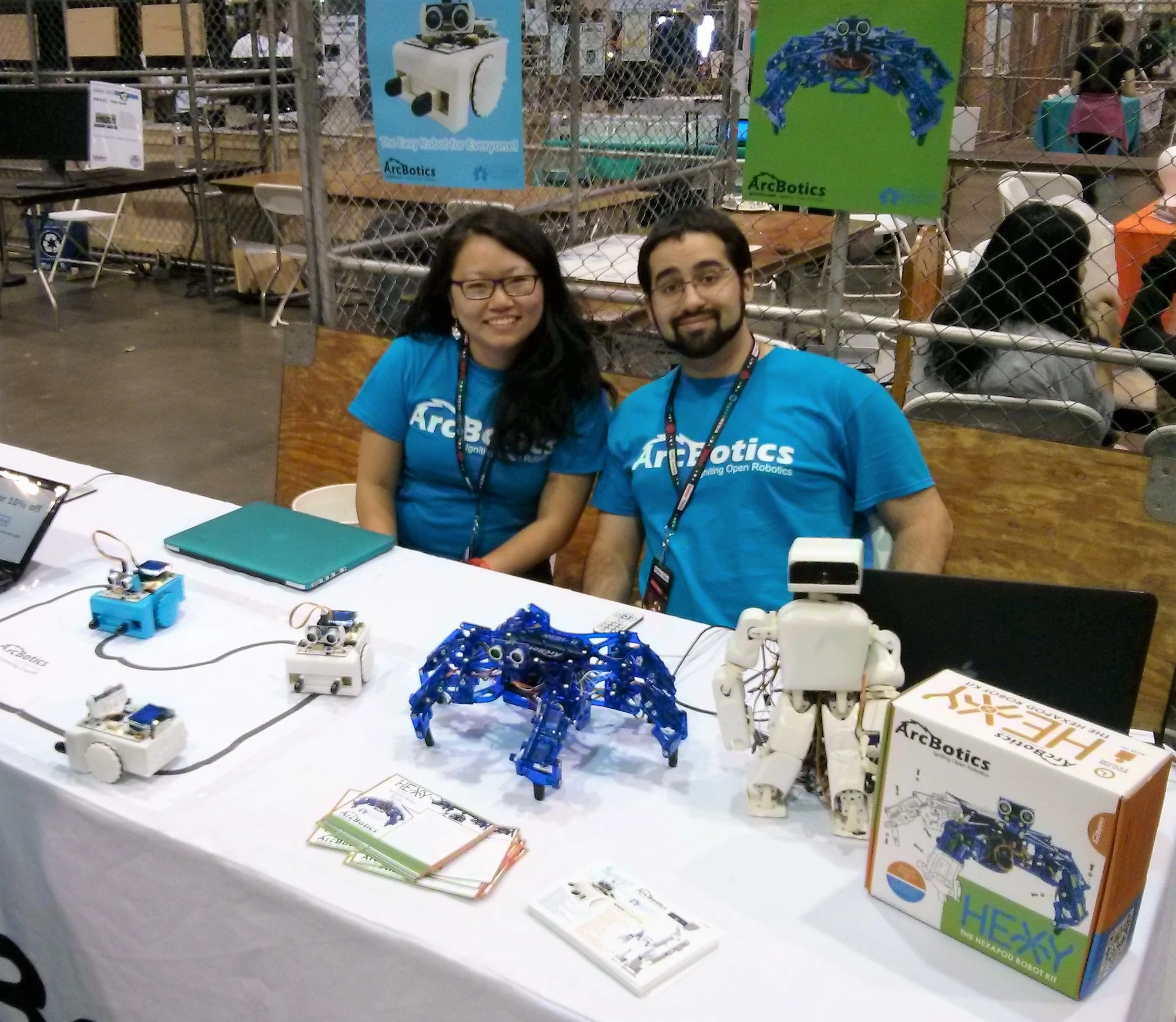 Two people at a table with robots