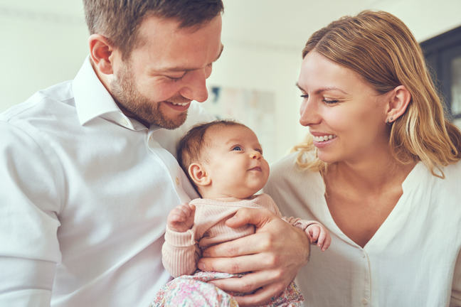 A couple holding their newborn baby.