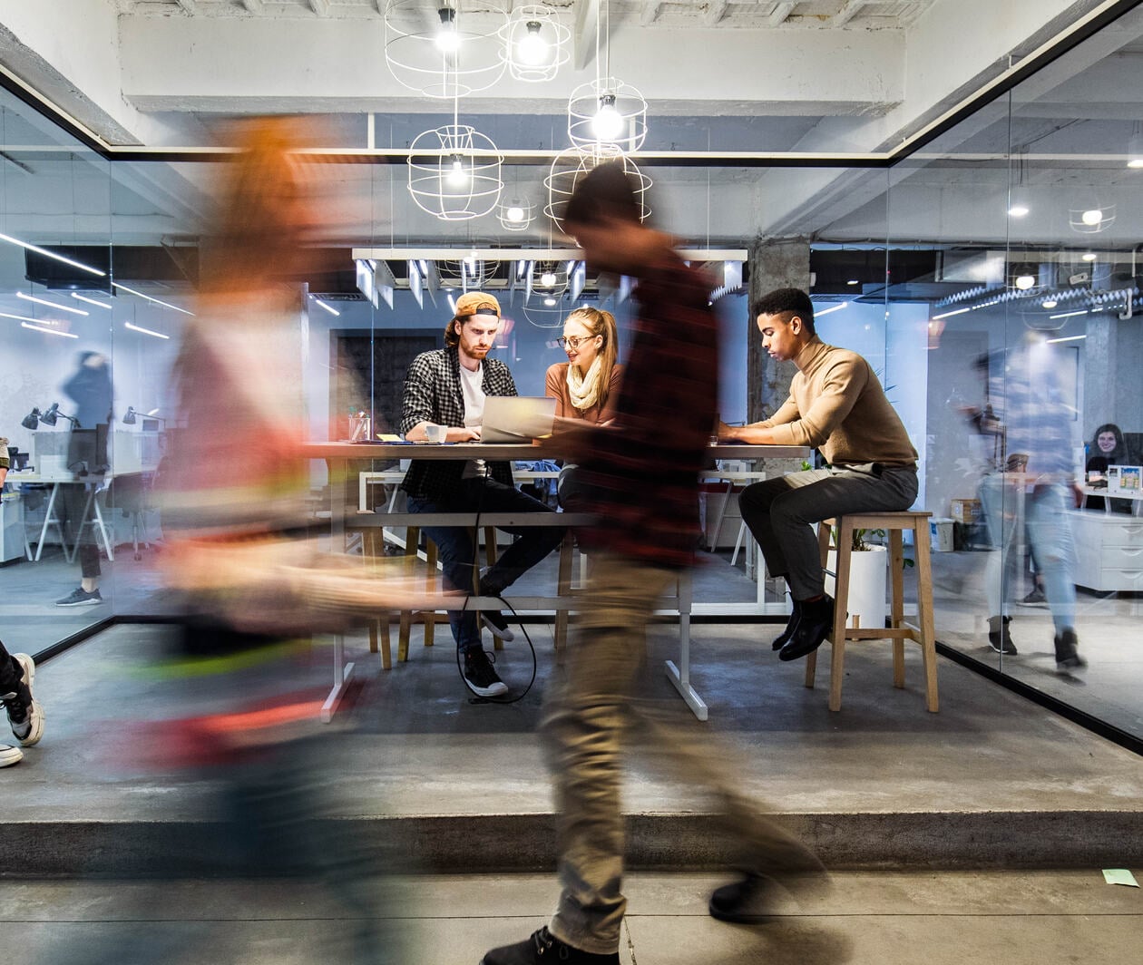 Young creative people working in the office among people in blurred motion