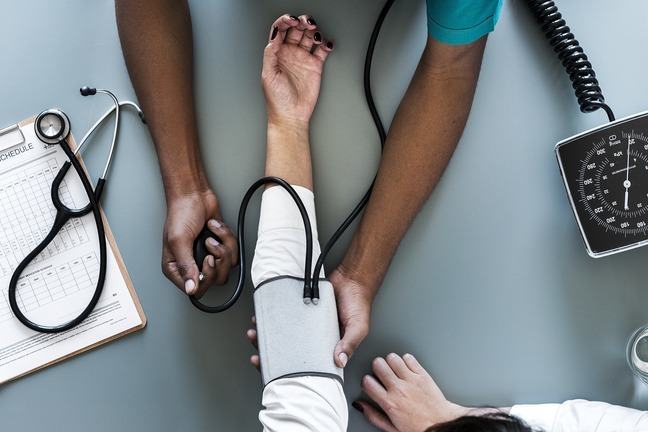 Doctor using blood pressure meter