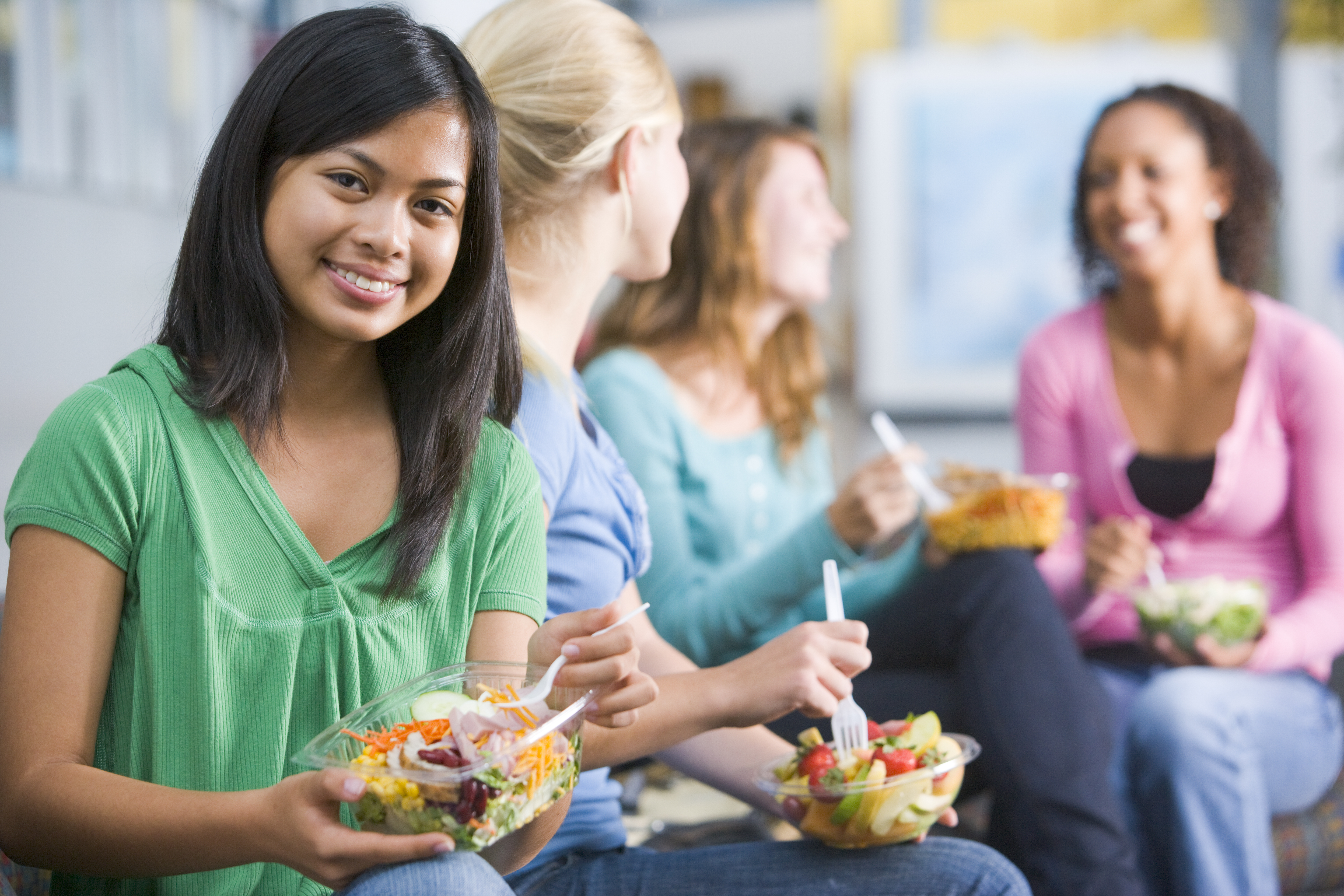 Teenage girls enjoying healthy lunches together