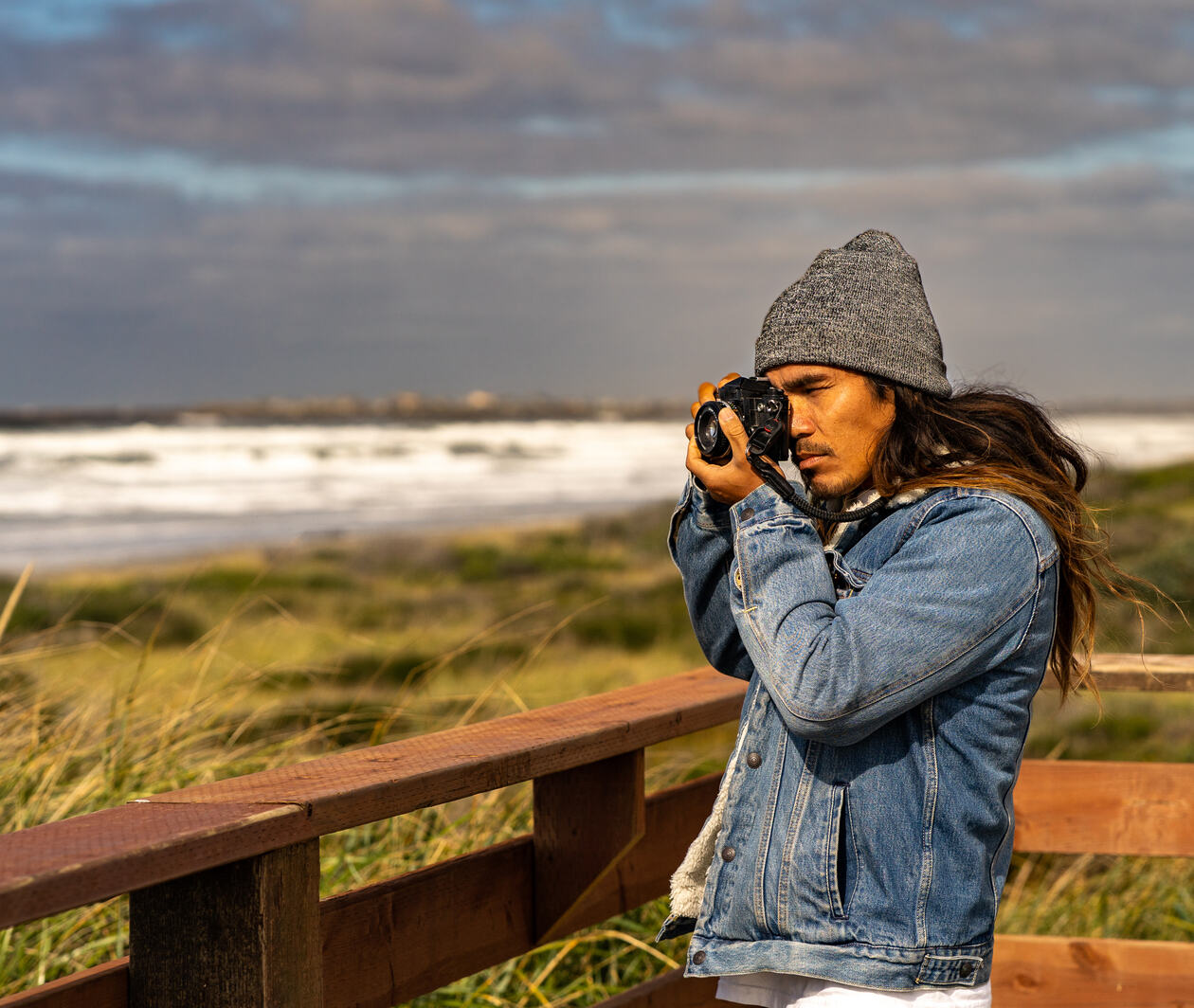 A man holding a camera, photographing a landscape