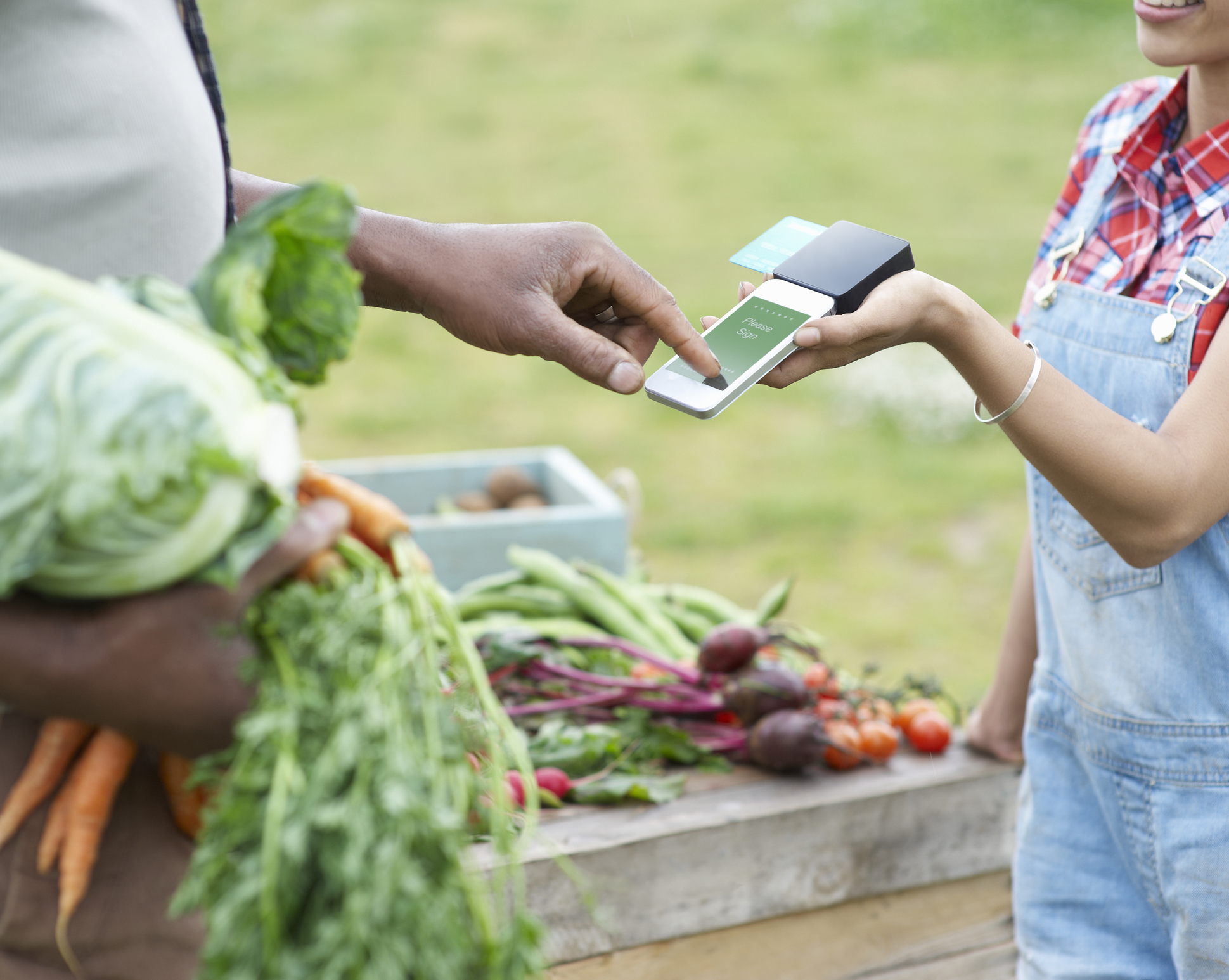 Man paying for vegetables with mobile add-on