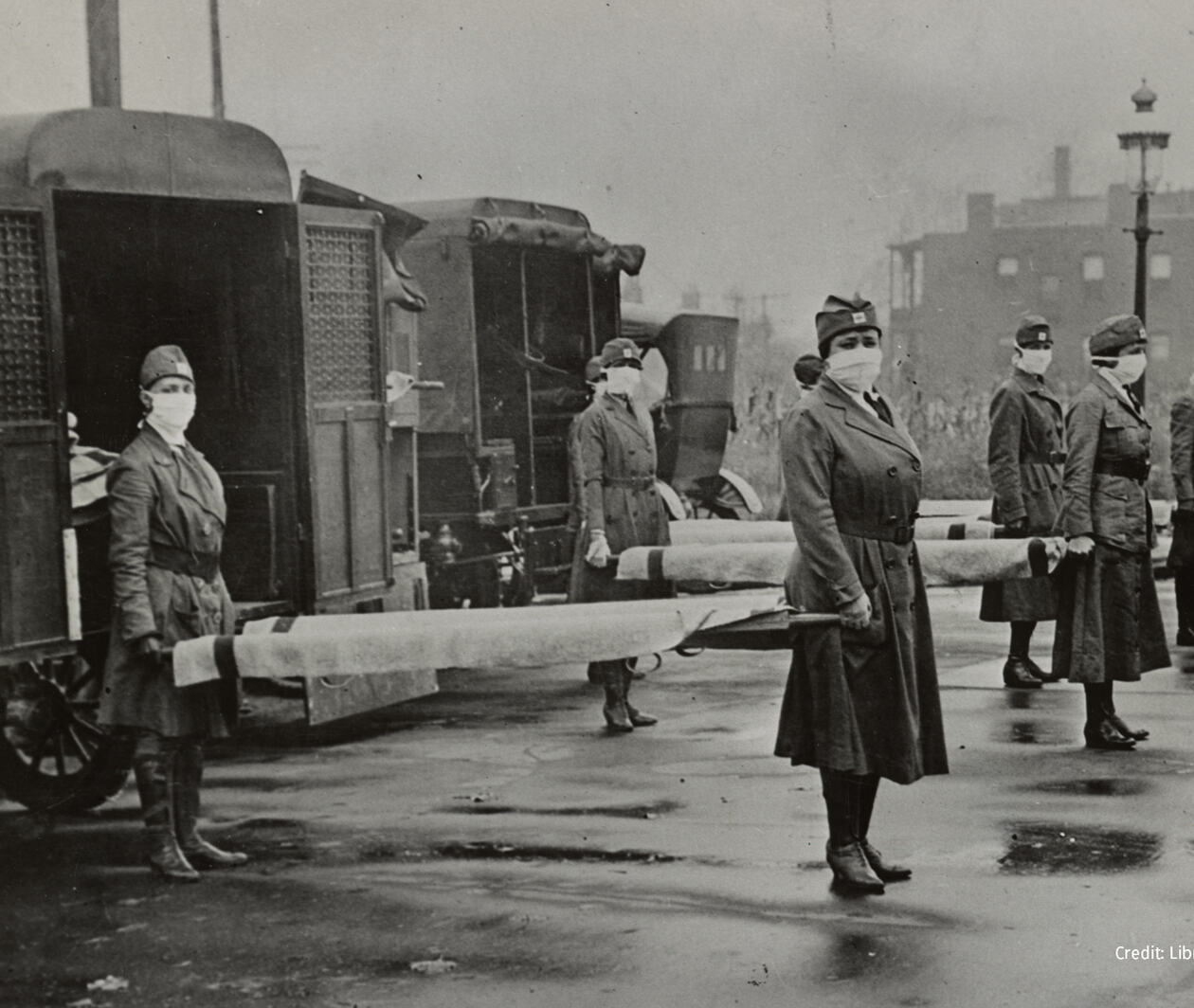 Nurses holding stretchers in front of ambulances during the Spanish Flu