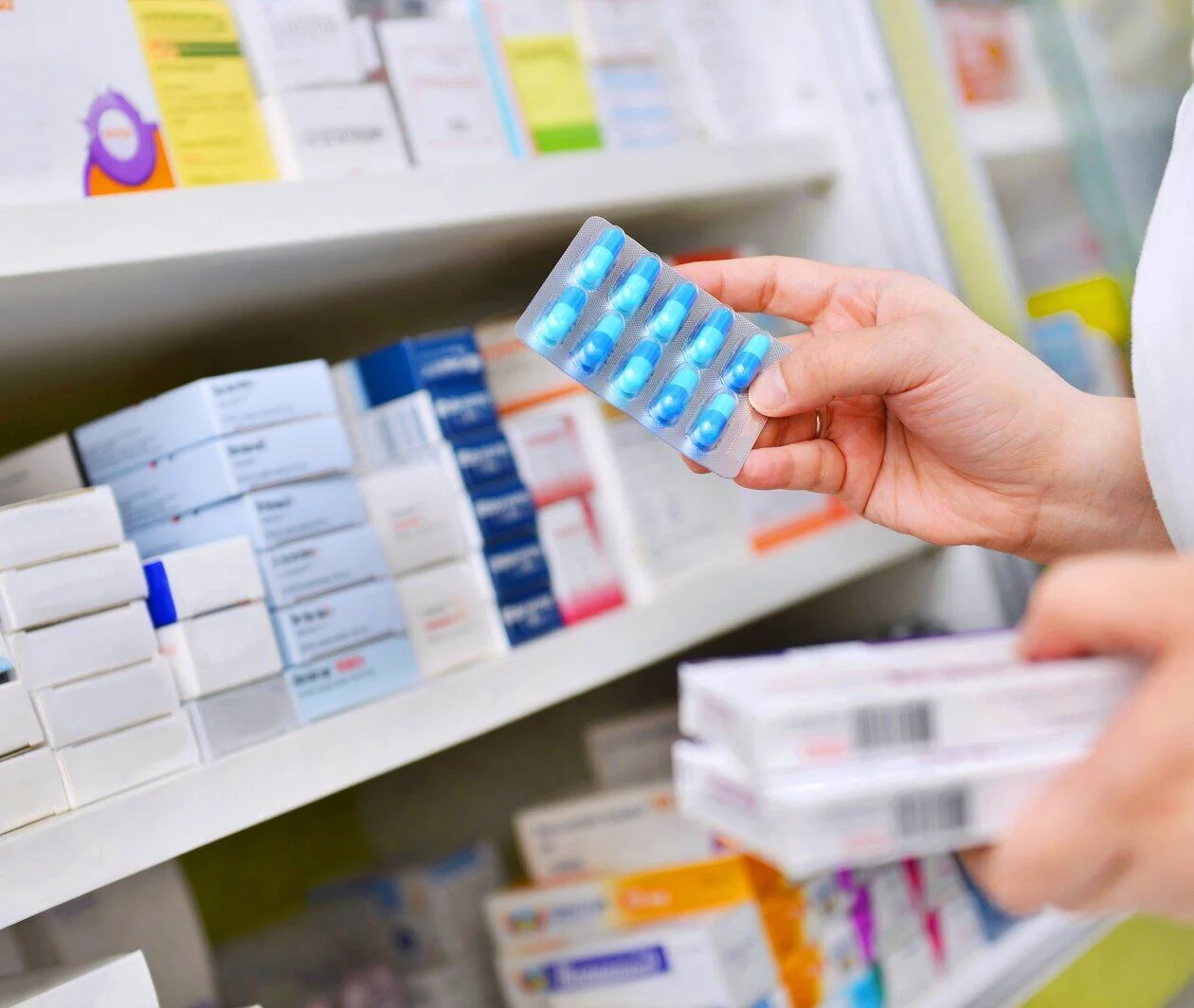 Pharmacists hold pill boxes and capsule packs for pharmacies.