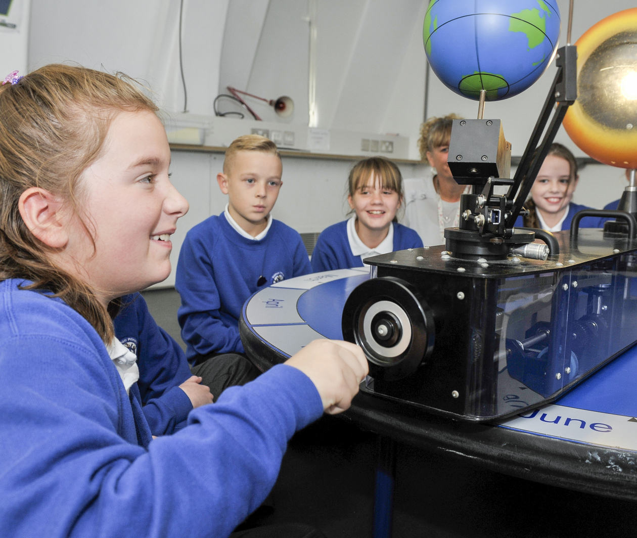 Teaching Primary Science: a child looks at a model of Earth and the wider Solar System