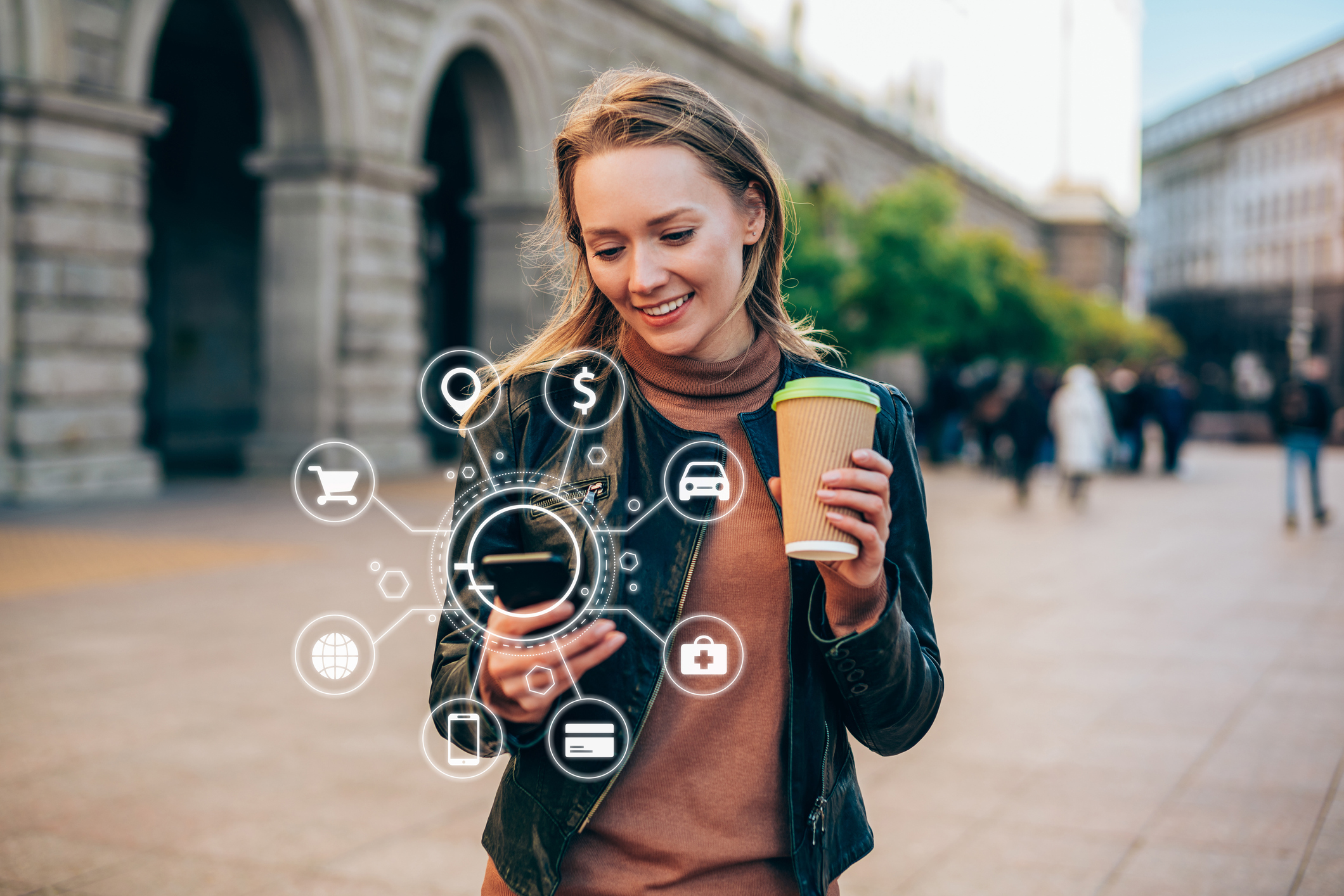 A person holding a coffee cup with digital symbols in front of them indicating money, car, medical, phone and internet.